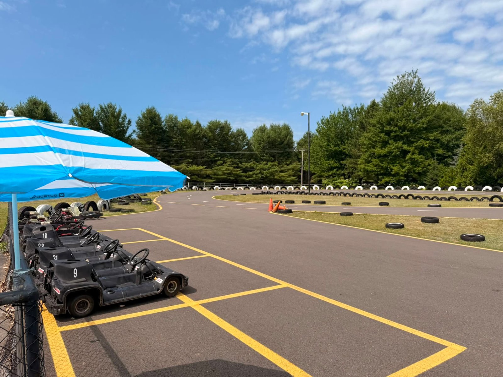 Piste vide, été à plein régime — les karts attendent à l'ombre leur prochaine course. 🏎️☀️